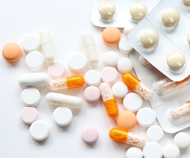 An assortment of white and orange pills on a white background.